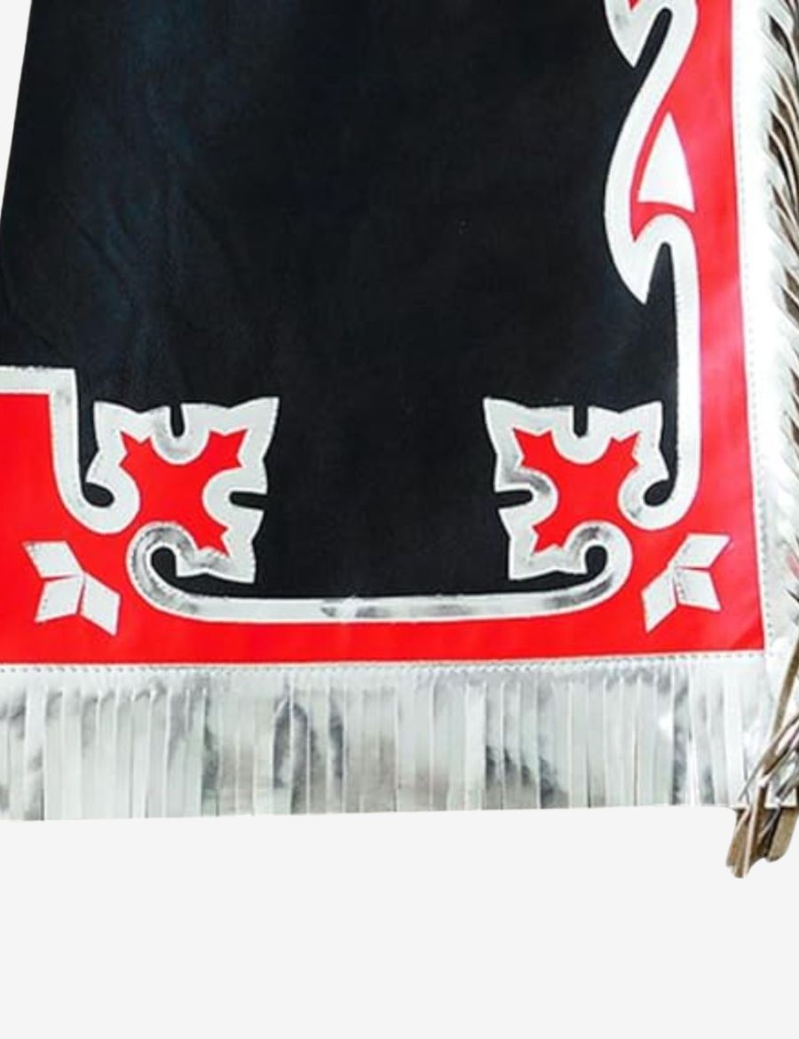 Lower leg detail of black rodeo chaps with red western overlays and metallic silver fringe trim.
