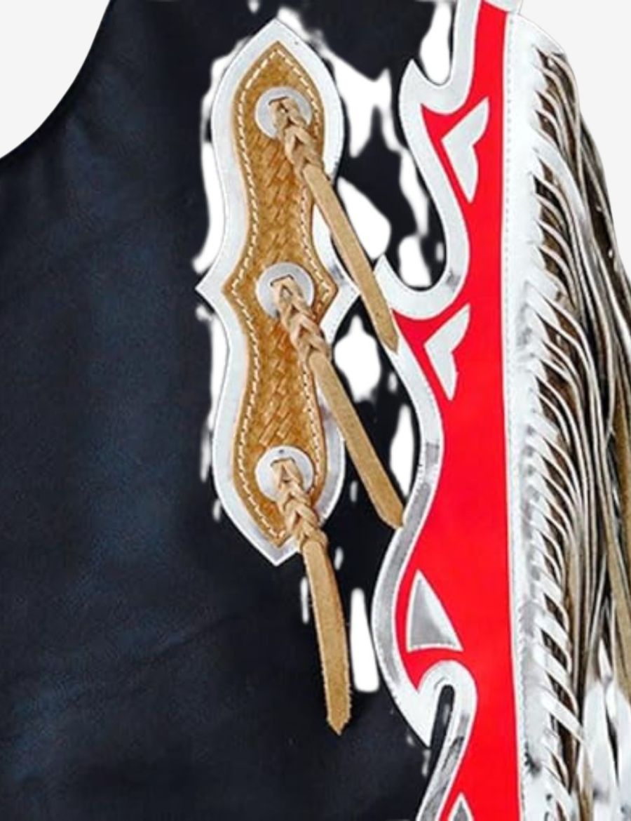 Close-up tooling detail of black arena edge bull riding chaps with basket weave leather and braided tassels.