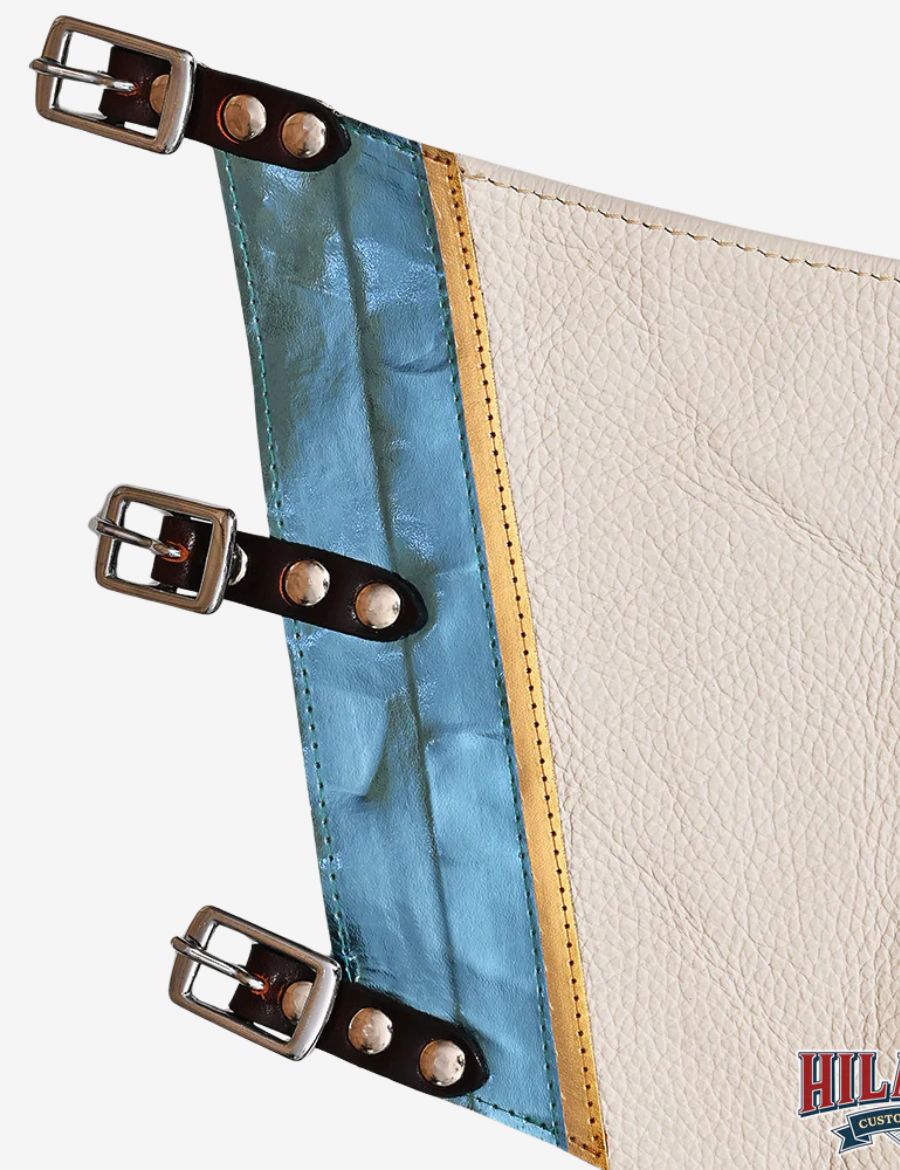 Inside view of white leather rodeo chaps with adjustable buckle straps and metallic blue western trim.