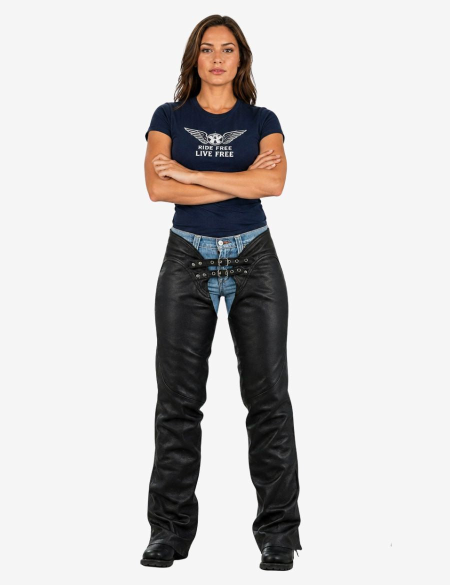 Female model wearing black assless motorcycle chaps paired with denim jeans and fitted shirt, styled for confident motorcycle riding and streetwear look.