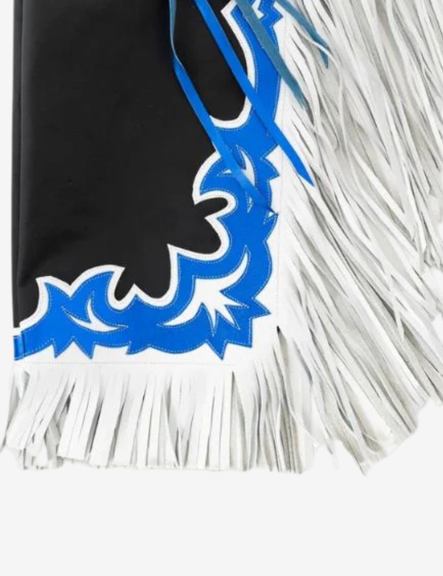 Detailed fringe view of black rodeo chaps with layered white leather fringe and blue western trim accents.