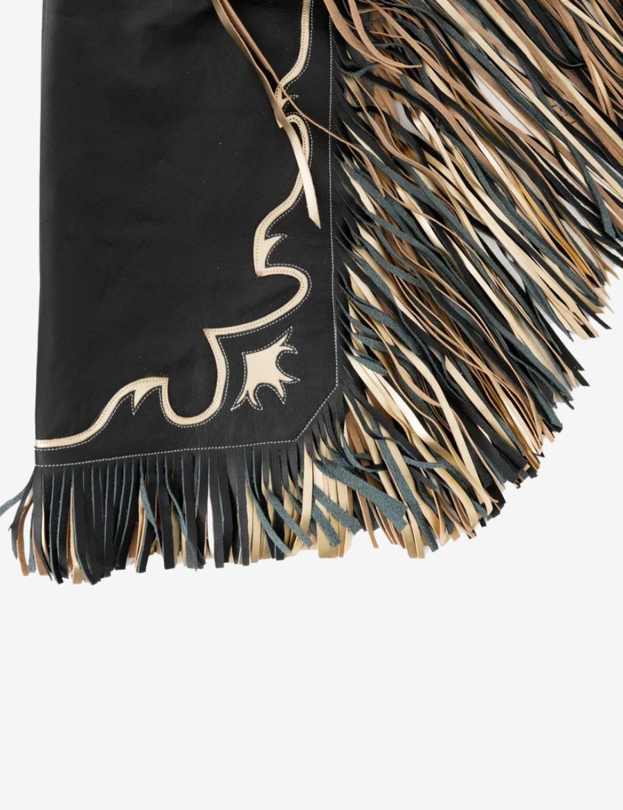 Close-up fringe view of black rodeo chaps featuring layered tan and black leather fringe with western trim.