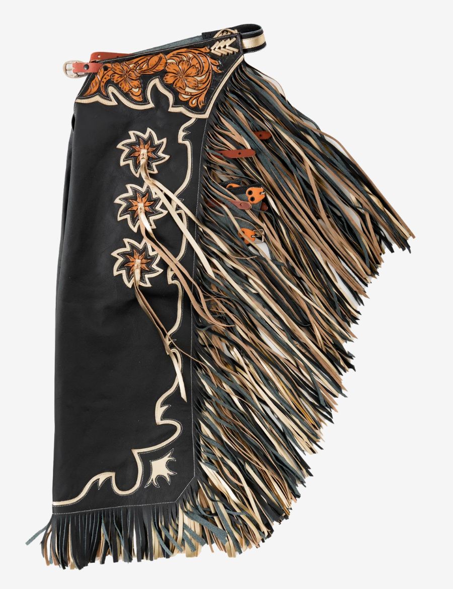 Black rodeo chaps with floral tooled yoke, layered tan and black fringe, and western leather detailing.