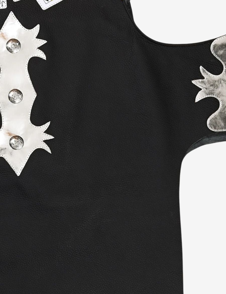 Close-up leather texture of black and silver bull riding chaps with silver overlays and premium rodeo craftsmanship.