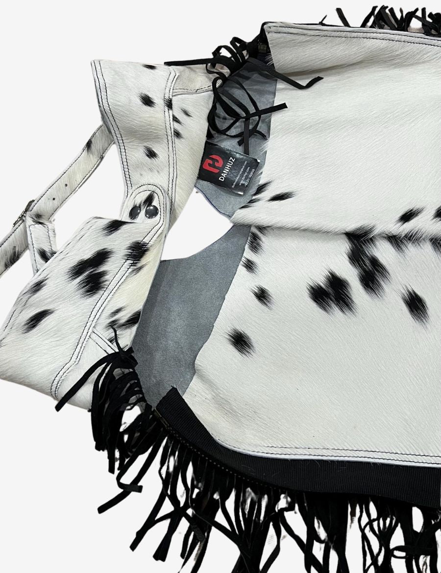 Rear close-up view of black and white hair-on hide western chaps showing detailed cowhide texture and finish.