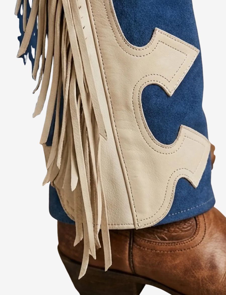 Close-up of blue and ivory womens fringe chaps highlighting handcrafted leather fringe, contrast panel design, and western craftsmanship.