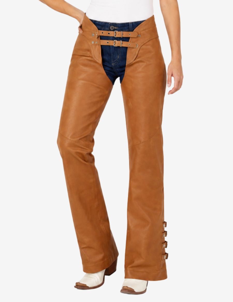 Angled front view of brown leather chaps for women with smooth leather finish and side buckle accents.
