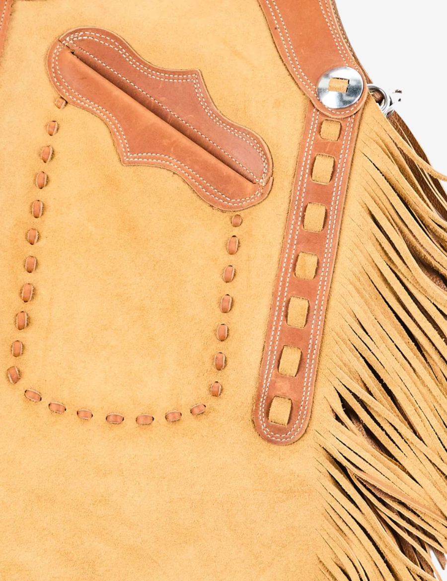 Close-up of buckskin chinks chaps showing leather stitching, fringe detailing, and handcrafted western design.