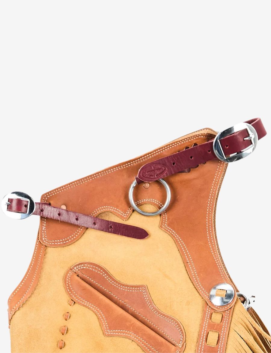 Upper view of buckskin chinks chaps with adjustable leather straps, metal rings, and western craftsmanship.