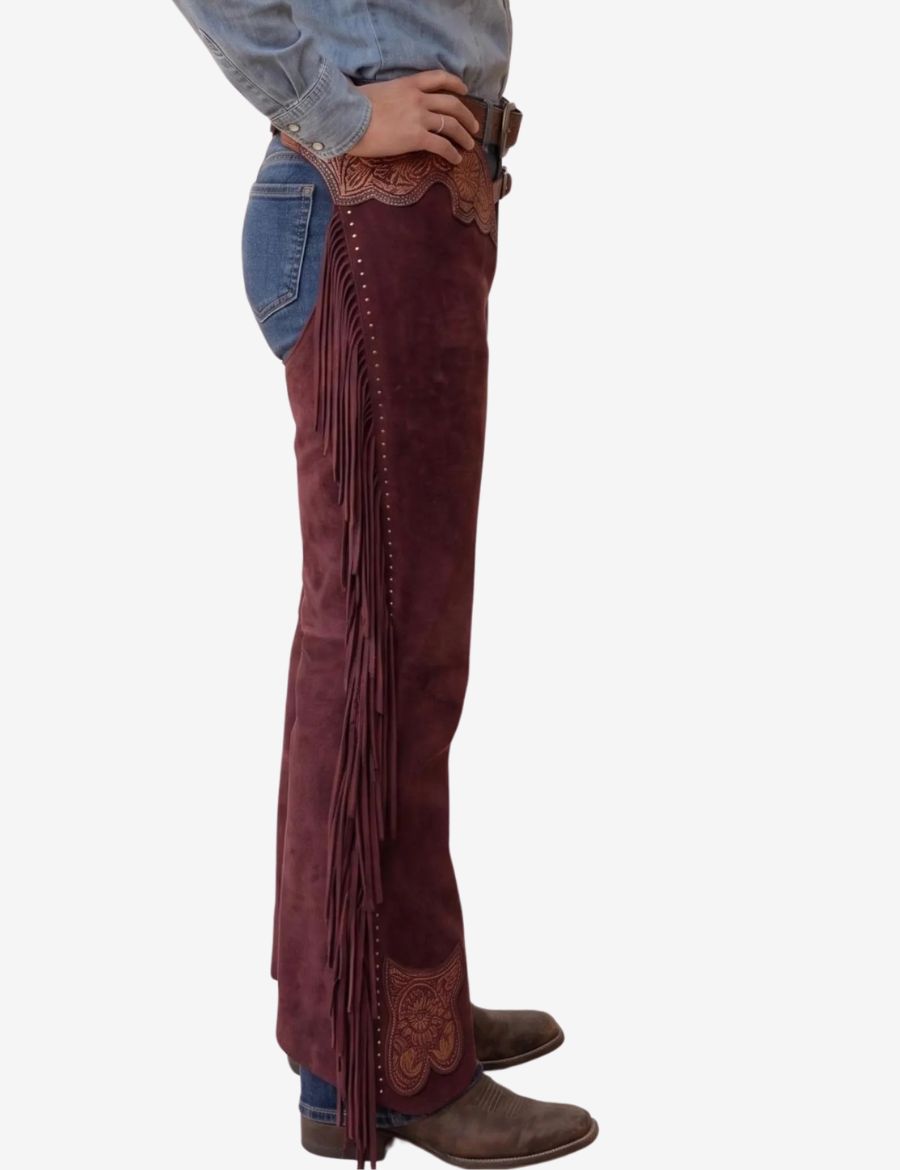 Side profile of burgundy leather western chaps for women with detailed tooling and extra-long fringe trim.