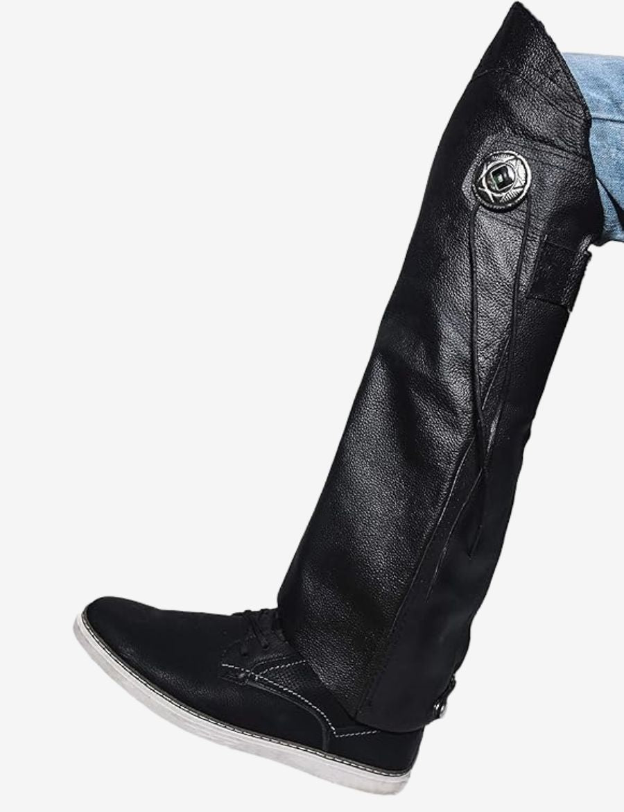 Close-up of black leather motorcycle half chaps showcasing premium leather texture, decorative concho accent, secure fastening system