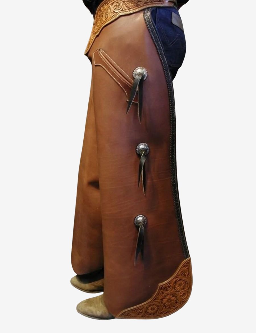Angled view of brown leather batwing chaps featuring conchos, utility pocket, and traditional cowboy design.