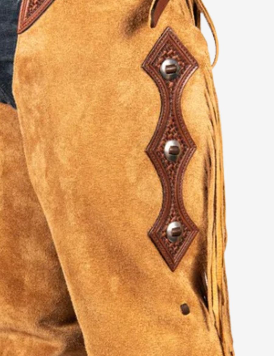 Close-up of tooled leather concho accents on tan cowboy buckskin show chaps.