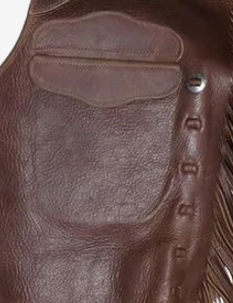 Close detail of oil tan leather cowboy chinks chaps featuring premium leather texture, reinforced upper panel, and western craftsmanship.