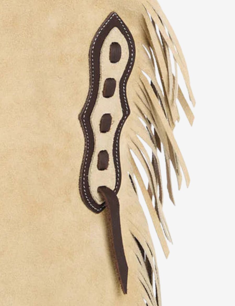 Close-up of cowboy cream suede chinks chaps showing stitched leather trim, suede finish, and fringe craftsmanship.