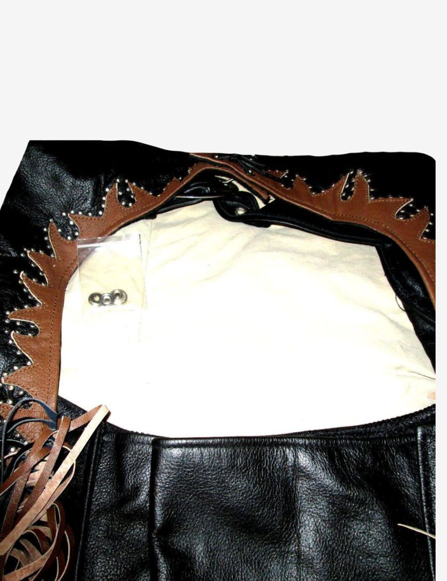 Close-up of the inner waist area of black cowhide leather western chaps with decorative brown trim.