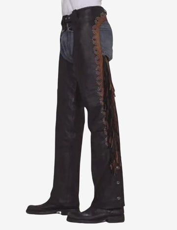Side view of black cowhide leather men’s western chaps with brown studded trim and fringe detailing.