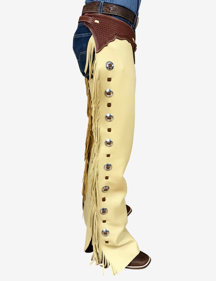 Side profile of cream leather western shotgun chaps featuring fringe trim, silver hardware, and rodeo-inspired design.