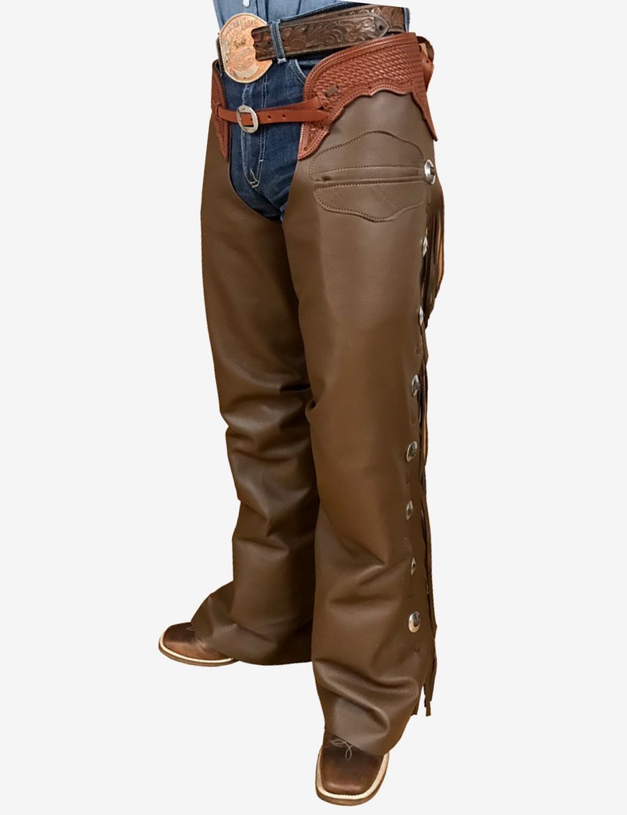 Angled front view of dark brown leather shotgun chaps featuring western conchos, fringe, and tooled yoke.