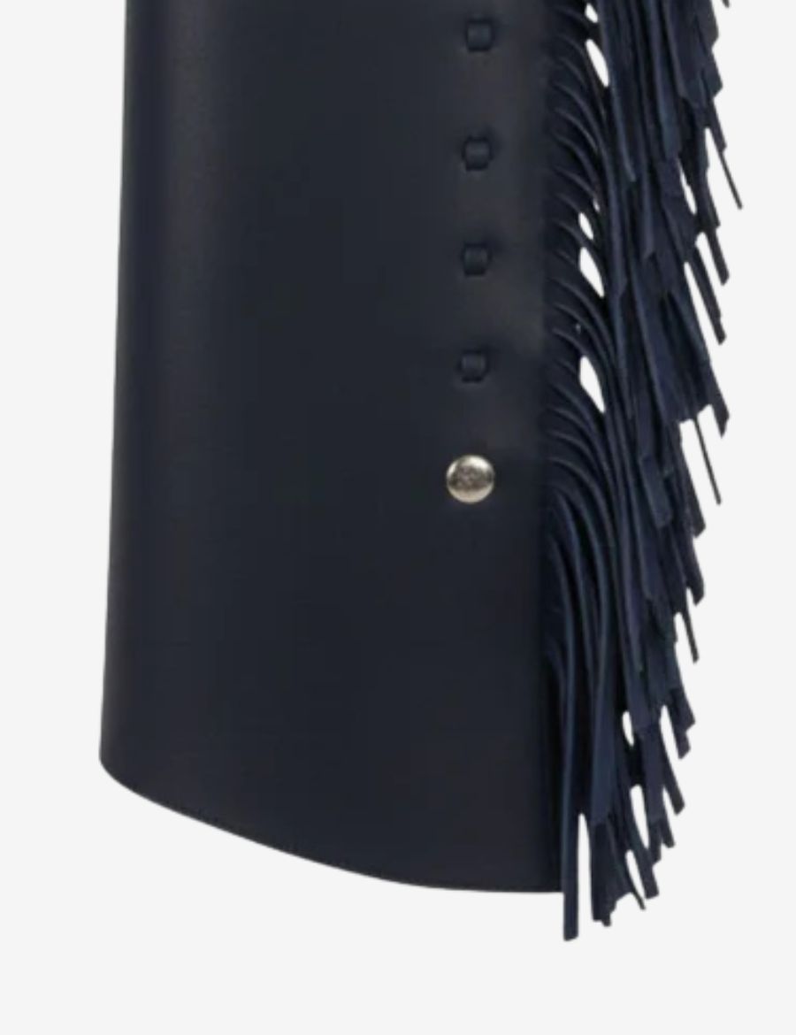 Close-up of deep navy leather shotgun chaps highlighting long fringe, smooth leather, and western craftsmanship details.