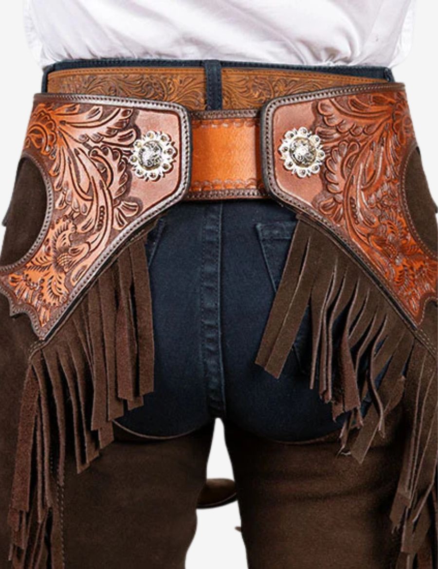 Rear close-up view of espresso brown cowboy chaps with floral tooled leather panels and suede fringe accents.