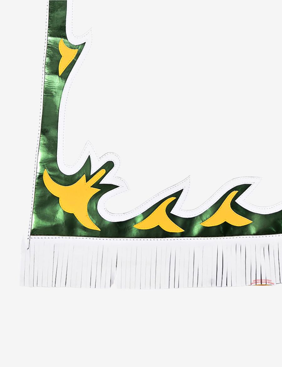Lower leg close-up of white rodeo chaps with metallic green overlay, yellow accents, and fringe hem detailing.