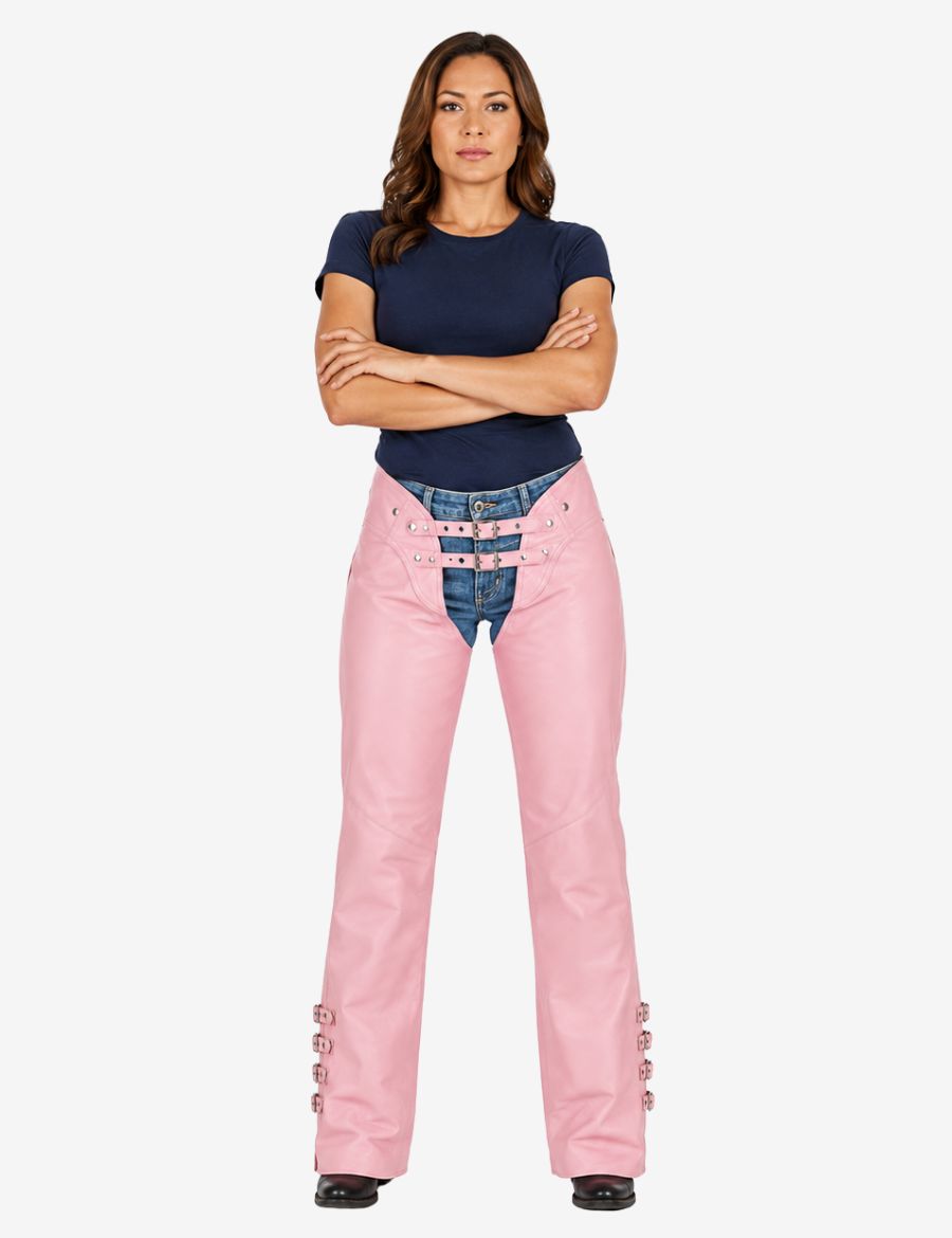 Female model wearing pink genuine leather motorcycle chaps over denim jeans with relaxed arms posing in riding stance.