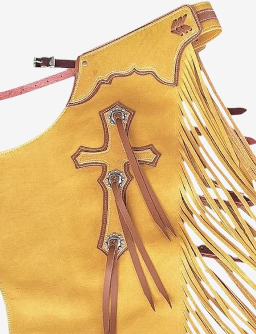Close-up view of golden tan bull riding chaps featuring cross leather detailing and western fringe.