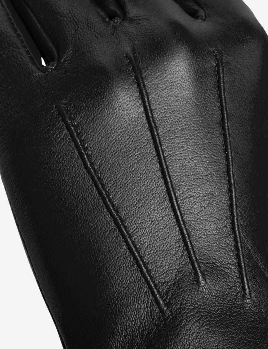 Close-up detail of leather long cuff black gauntlet gloves showing premium leather texture, reinforced stitching, and tailored finger panels.
