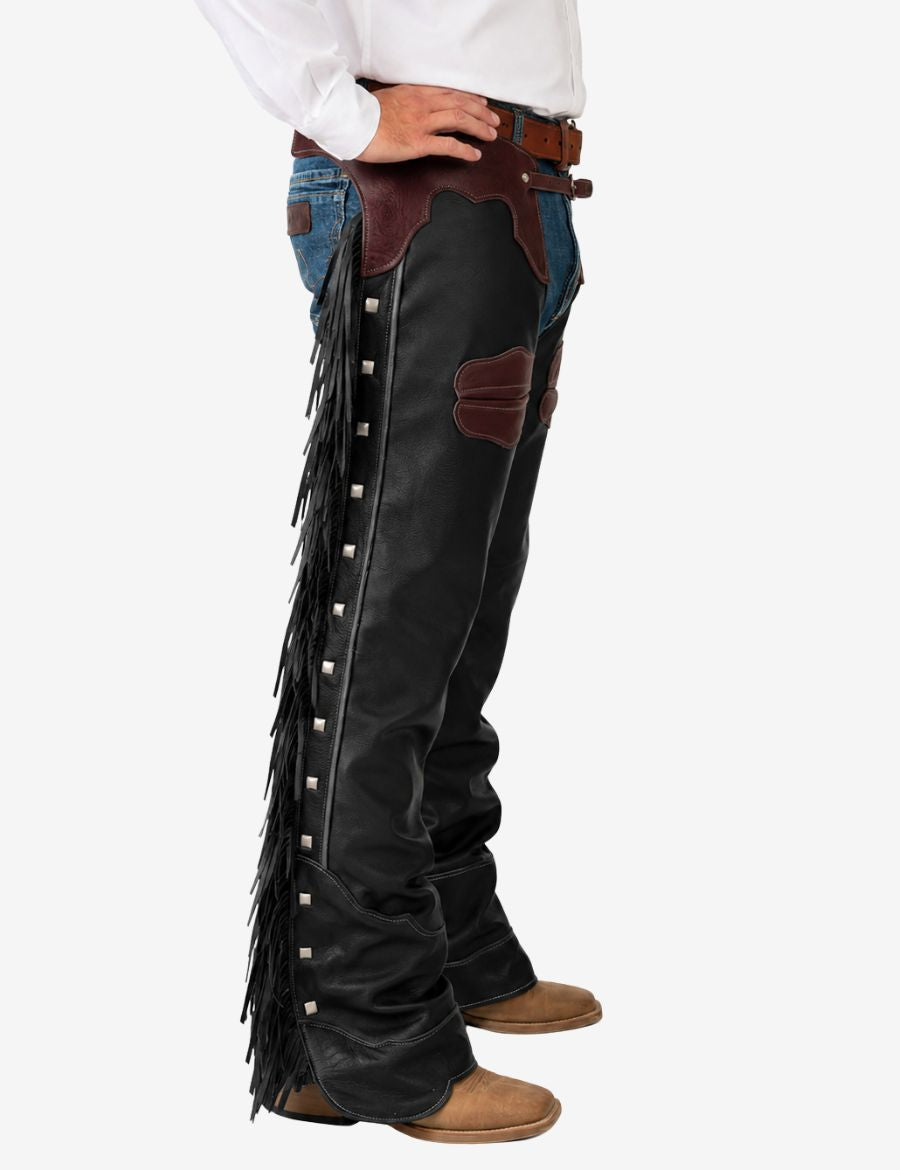 Side profile of men’s black leather cowboy chaps featuring long fringe and western ranch rider look.