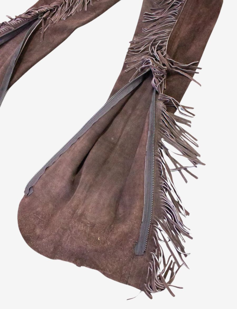 Inside detail of brown suede western chaps showing leather fringe lining and lace-up waist adjustment.