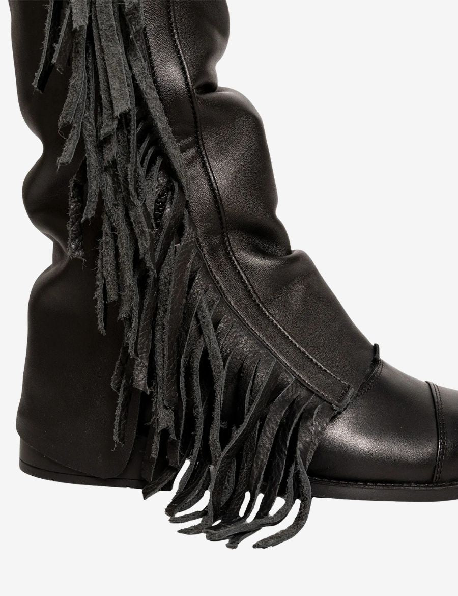 Close-up detail of black leather fringe on western cowboy riding chaps.