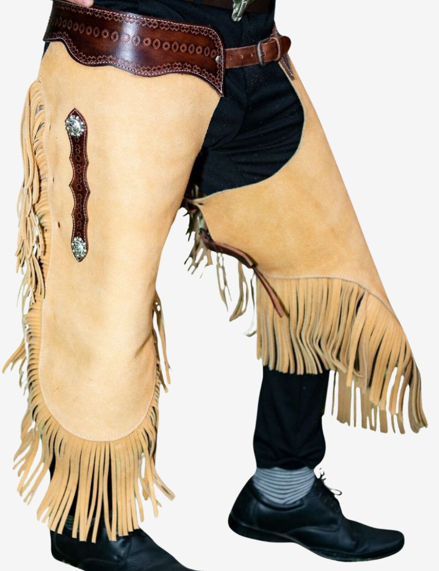 Close front detail of ranch rider leather chinks chaps with cream suede leather, long fringe, and western concho accents.