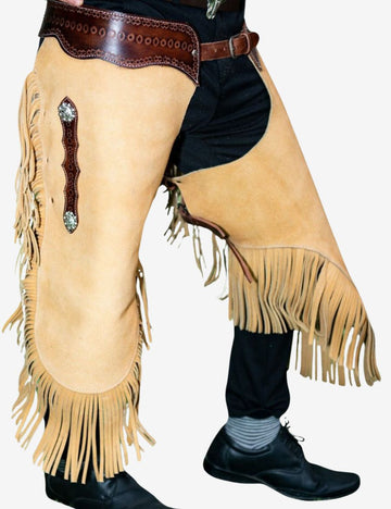 Close front detail of ranch rider leather chinks chaps with cream suede leather, long fringe, and western concho accents.