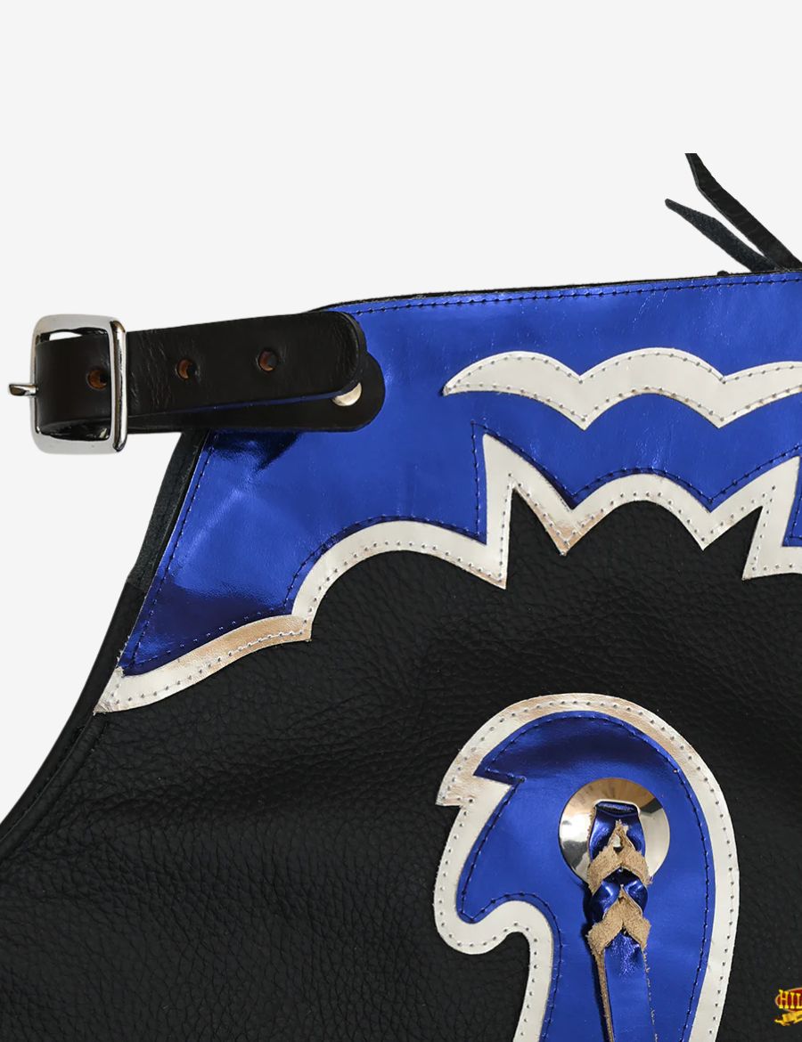 Close-up yoke view of black leather rodeo chaps with blue and silver fringe and western tooled detailing.