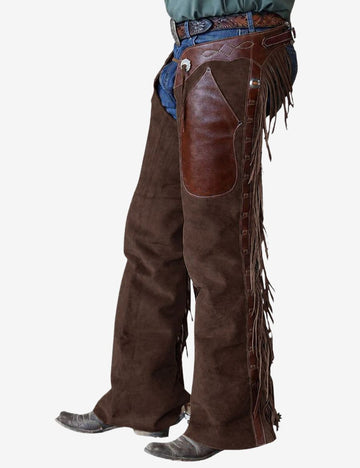 Left front view of rustic brown suede shotgun chaps with rich leather overlays, western fringe, and rugged cowboy styling.