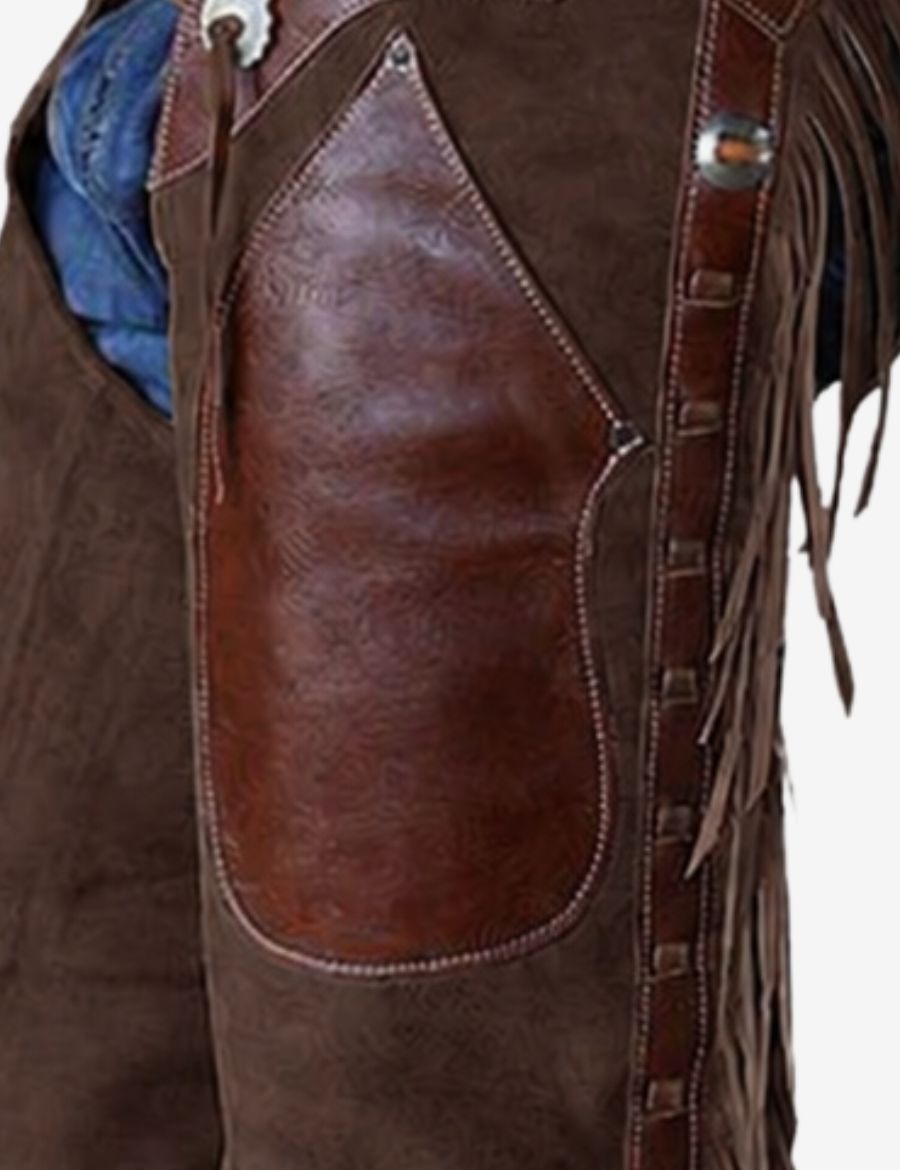 Upper leather panel detail of rustic brown shotgun chaps with decorative stitching and handcrafted western fringe accents.