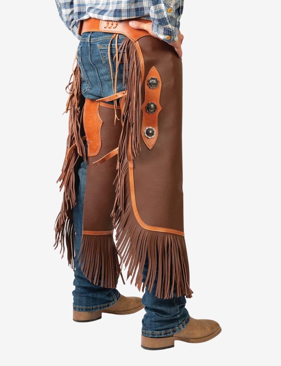 Angled front view of saddle brown concho chinks chaps with long fringe, leather trim, and rugged cowboy styling.