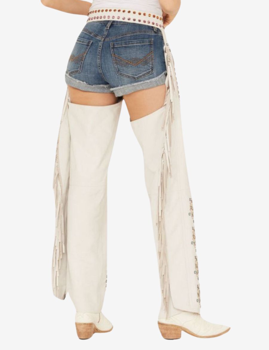 Back view of studded cowgirl chaps with side fringe detailing and white western leather construction.