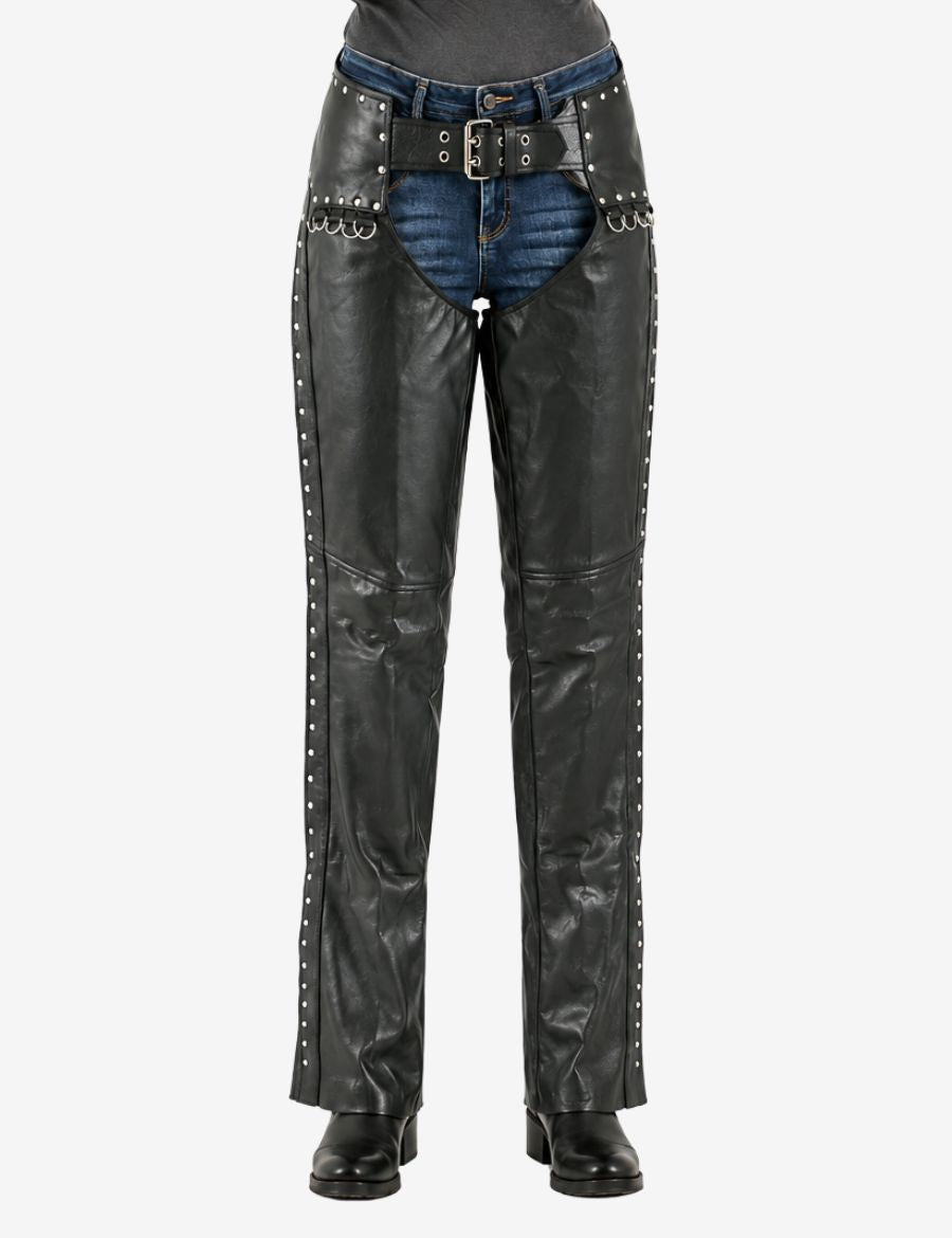 Close-up front view of studded women’s leather motorcycle chaps showing belt buckle, rivet detailing, and reinforced leather riding panels.