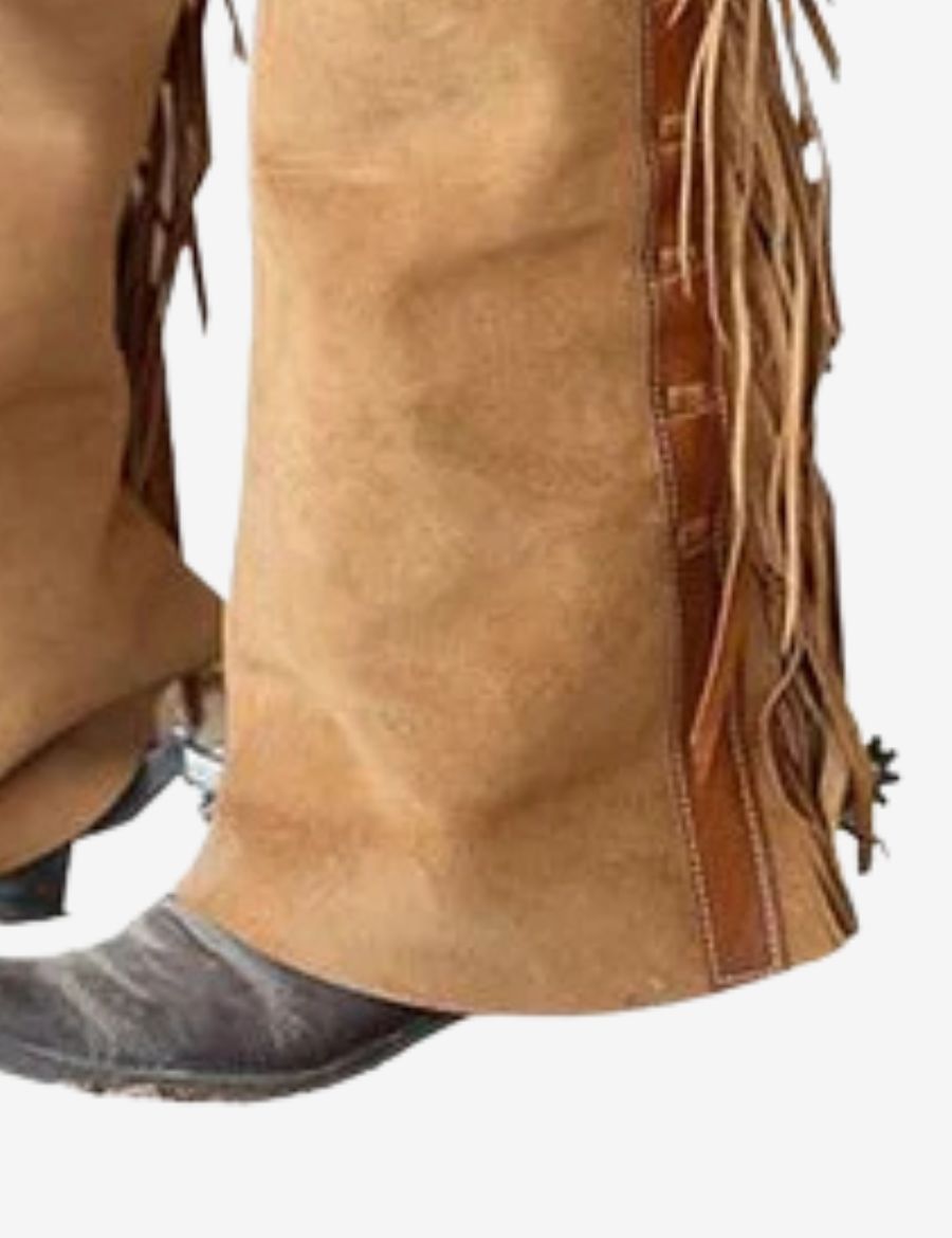 Lower leg close-up of tan suede shotgun chaps showing suede texture, fringe trim, and durable western construction.