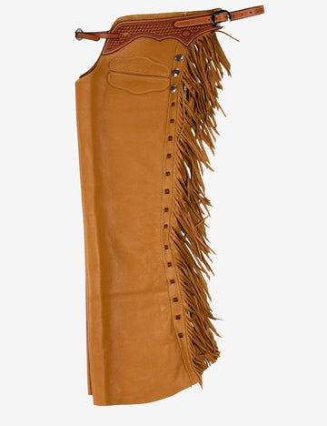 Side view of tooled leather cowboy shotgun chaps with long fringe, braided yoke, and tan western riding design.