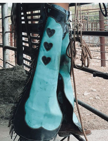 turquoise cowgirl chaps with black scallop leather panels and heart accent detailing.