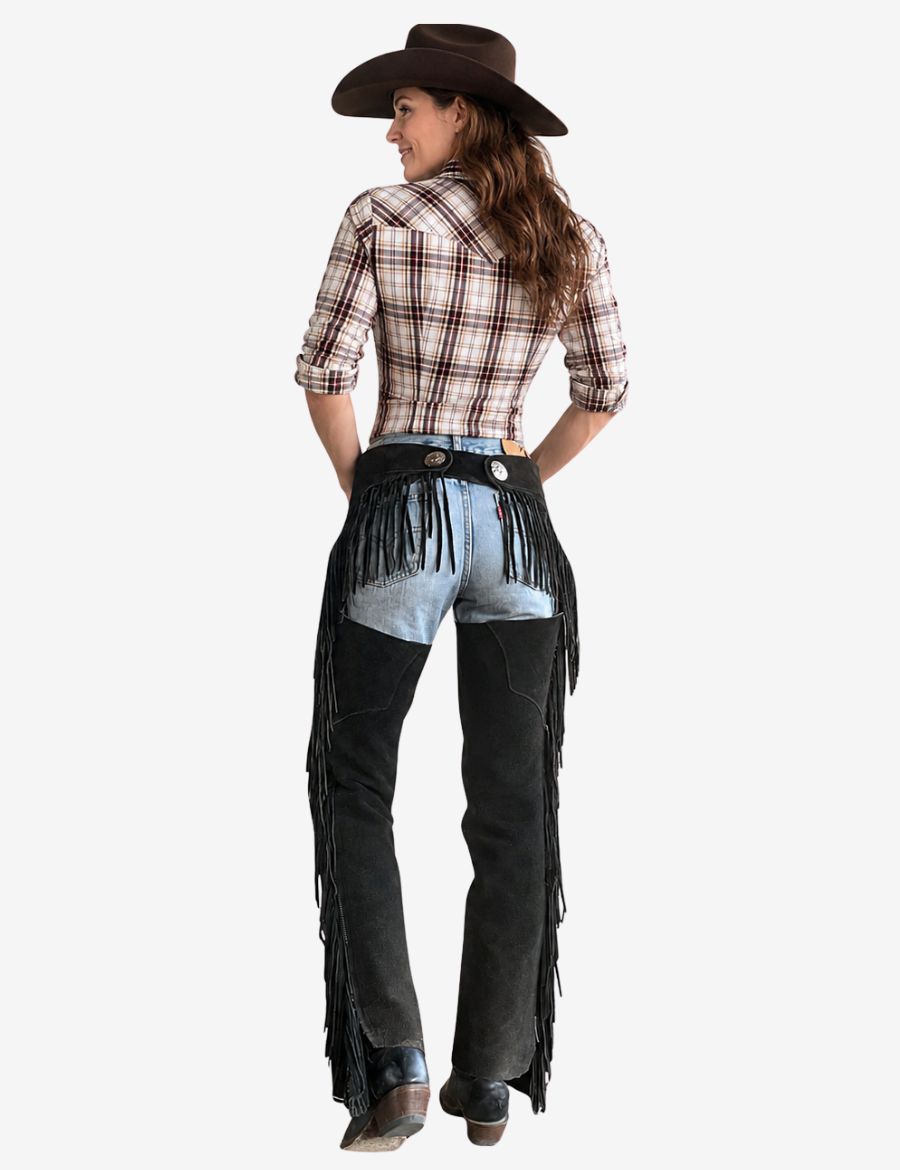 Back model view of women black western chaps with long fringe detailing and western cowgirl fashion styling.