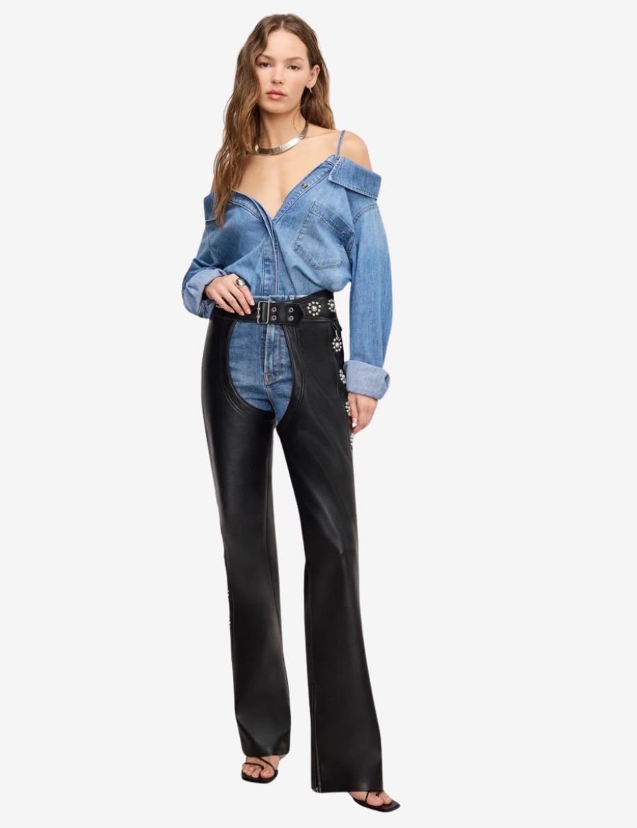 Full-length view of womens floral concho assless chaps styled with a western-inspired outfit, featuring premium black leather, silver floral conchos, and a sleek fashion-forward silhouette.