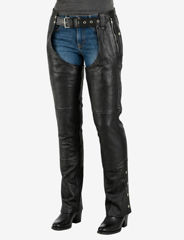 Front view of womens rider leather chaps featuring zip pocket detailing, double buckle waist closure, and straight-leg motorcycle fit worn by female model.